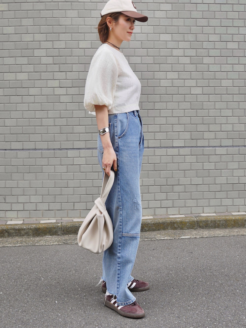ホワイト系のシャツ/ブラウス、ブルー系のデニムパンツ、ブラウン系のスニーカーを着用したレディースの春コーディネートの3枚目の写真