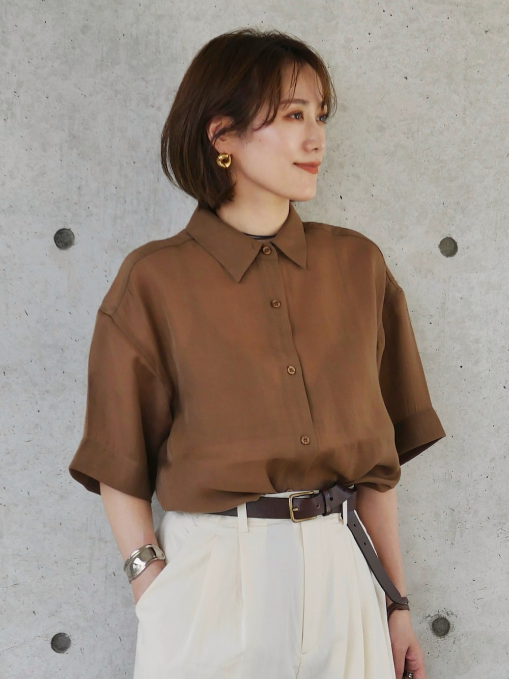 ブラウン系のシャツ/ブラウス、ホワイト系のスラックス、ブラウン系のショルダーバッグを着用したレディースの夏コーディネートの2枚目の写真