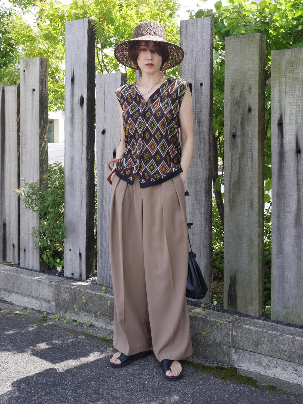 ベージュ系のその他パンツ、ブラック系のサンダル、ブラック系のベストを着用したレディースの夏コーディネートの2枚目の写真