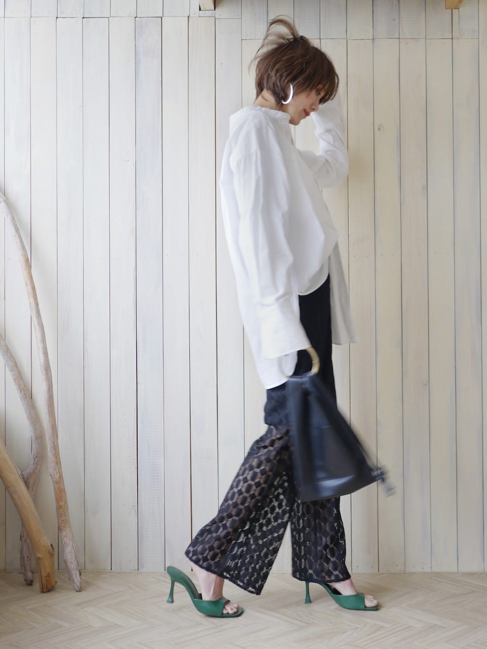 ブラック系のその他パンツ、ブラック系のショルダーバッグ、ホワイト系のシャツ/ブラウスを着用したレディースの春コーディネートの3枚目の写真