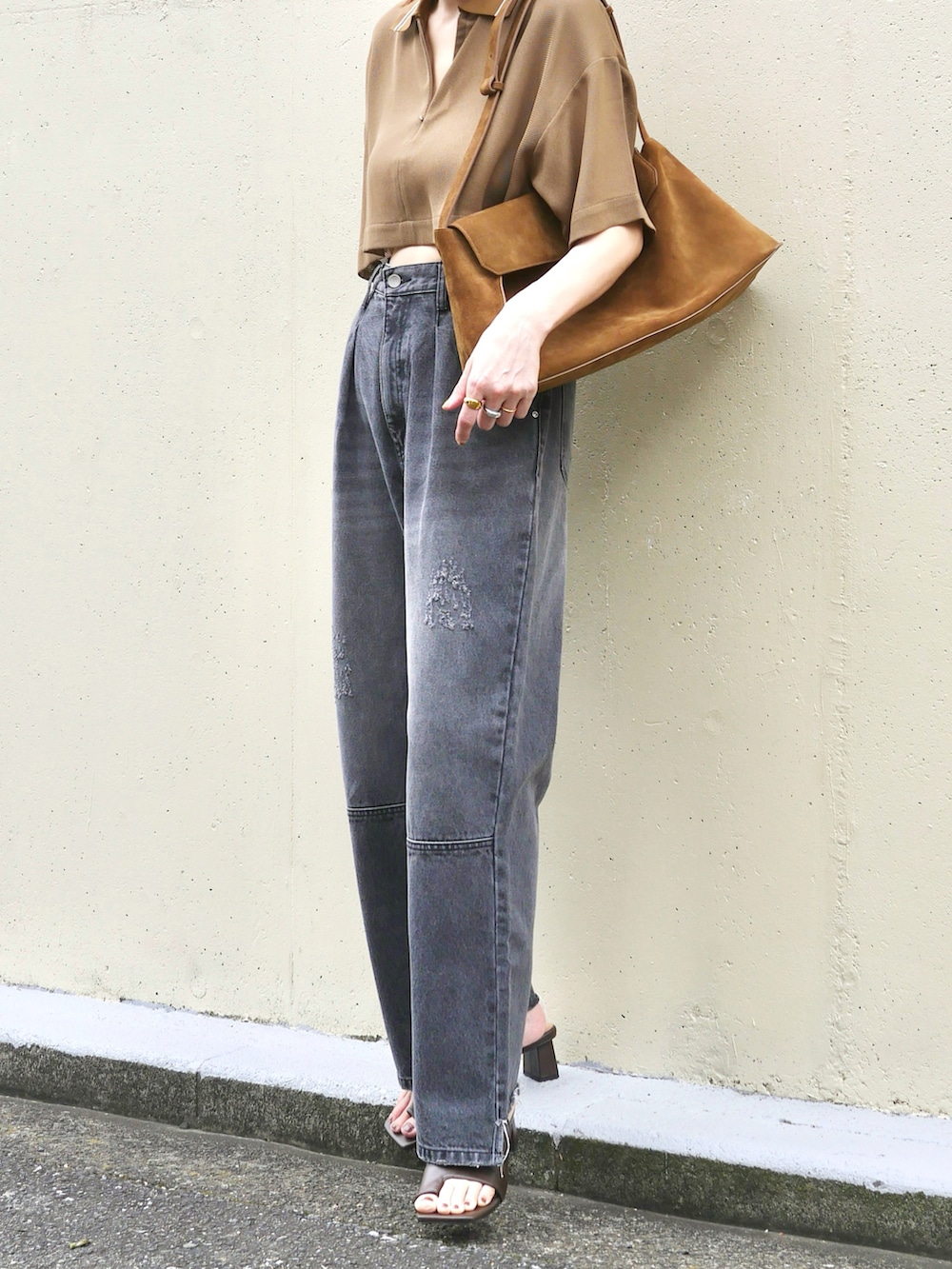 ブラウン系のニット/セーター、グレー系のデニムパンツ、イエロー系のショルダーバッグを着用したレディースの夏コーディネートの2枚目の写真