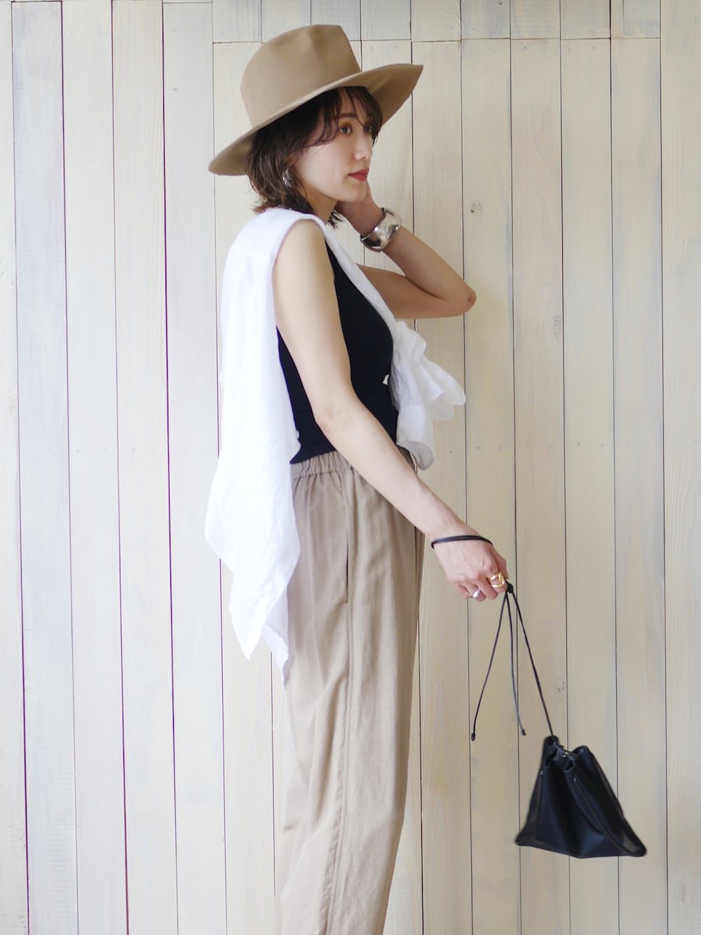 ホワイト系のシャツ/ブラウス、ブラック系のサンダル、ベージュ系のパンツを着用したレディースの夏コーディネートの3枚目の写真
