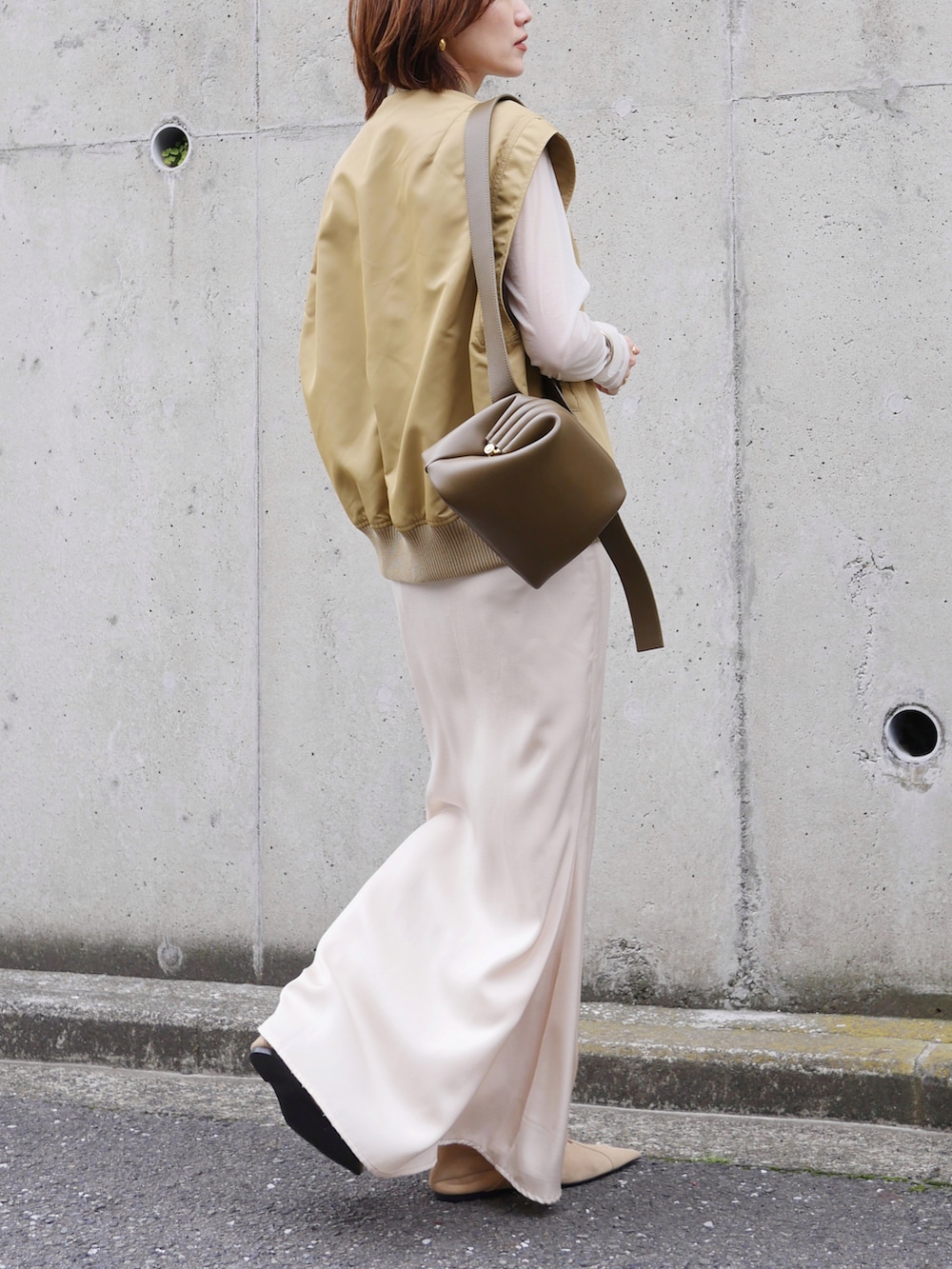 ベージュ系のその他アウター、ホワイト系のTシャツ/カットソー、グリーン系のショルダーバッグを着用したレディースの春コーディネートの3枚目の写真