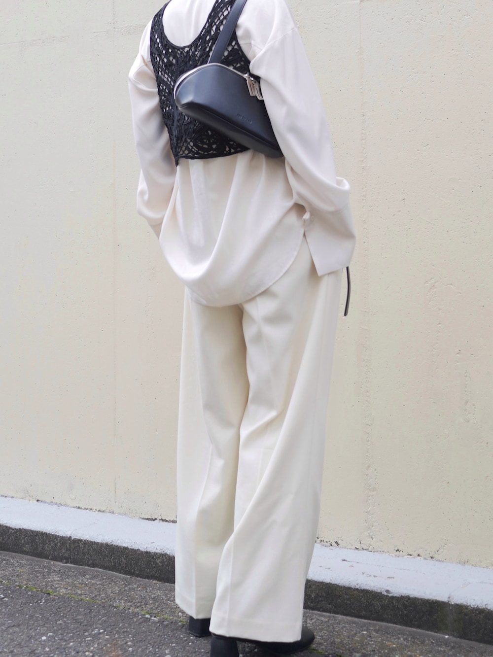 ホワイト系のシャツ/ブラウス、ブラック系のベスト、ホワイト系のスラックスを着用したレディースの春コーディネートの3枚目の写真