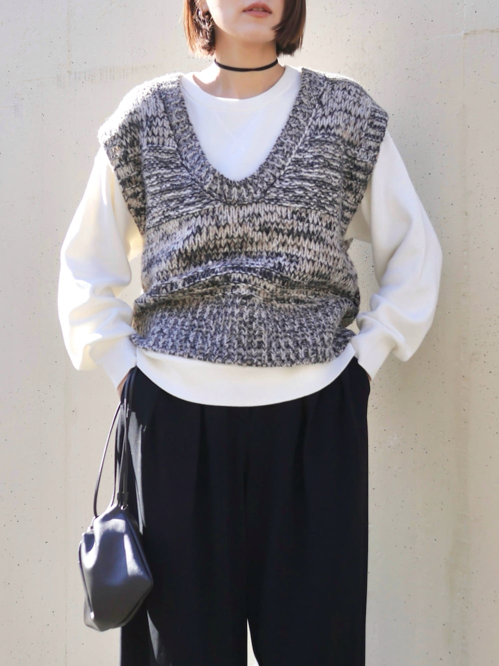 グレー系のベスト、ブラック系のブーツ、ブラック系のその他パンツを着用したレディースの冬コーディネートの2枚目の写真