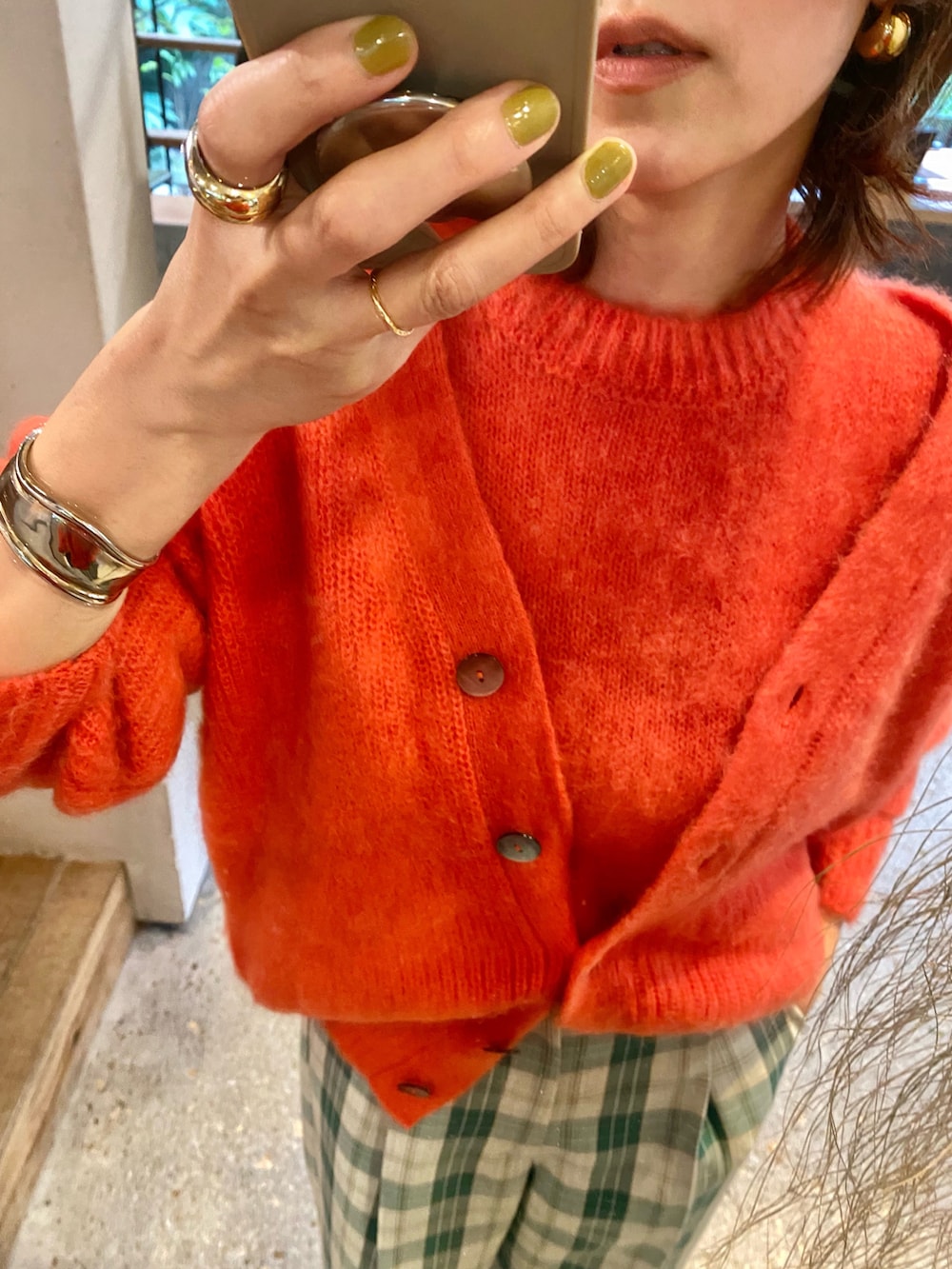 オレンジ系のカーディガン/ボレロ、オレンジ系のニット/セーター、グリーン系のその他パンツを着用したレディースの秋コーディネートの2枚目の写真