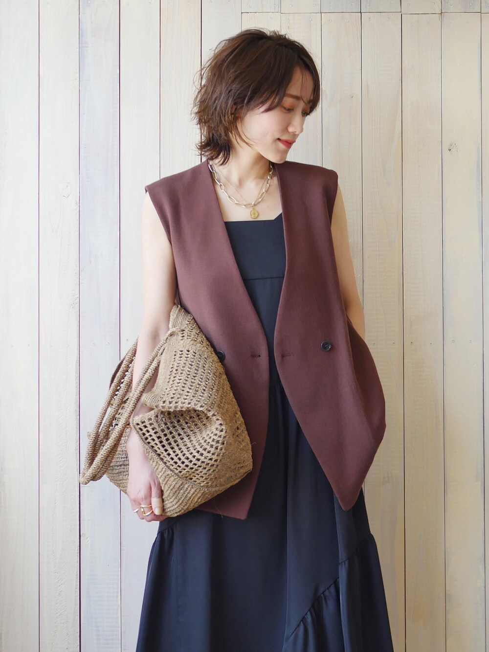 ブラック系のワンピース、ブラウン系のその他アウター、ベージュ系のかごバッグを着用したレディースの夏コーディネートの4枚目の写真