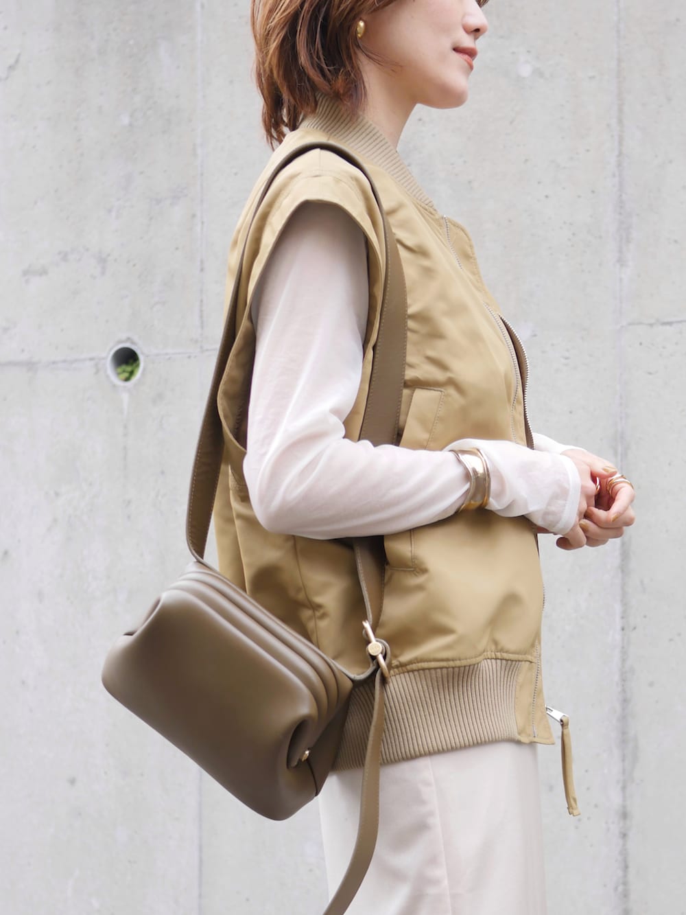 ベージュ系のその他アウター、ホワイト系のTシャツ/カットソー、グリーン系のショルダーバッグを着用したレディースの春コーディネートの4枚目の写真