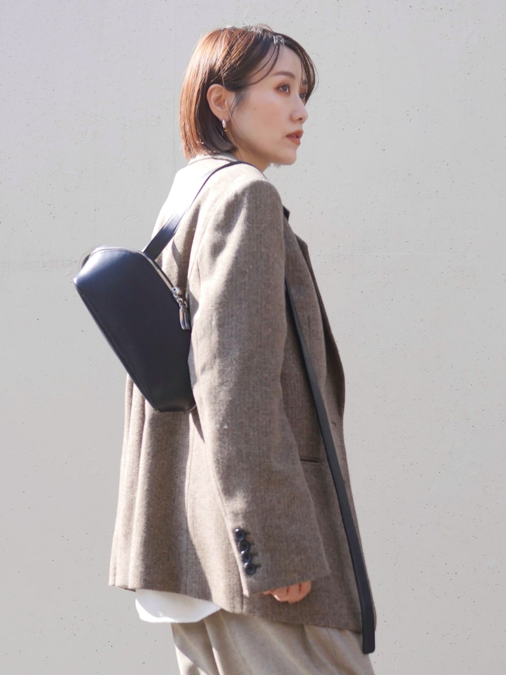 ベージュ系のテーラードジャケット、ベージュ系のその他パンツ、ブラック系のショルダーバッグを着用したレディースの秋コーディネートの5枚目の写真