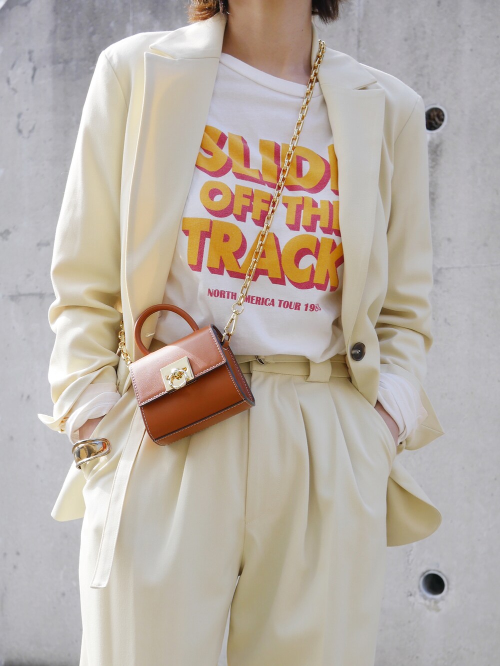 イエロー系のテーラードジャケット、イエロー系のその他パンツ、ホワイト系のTシャツ/カットソーを着用したレディースの冬コーディネートの5枚目の写真