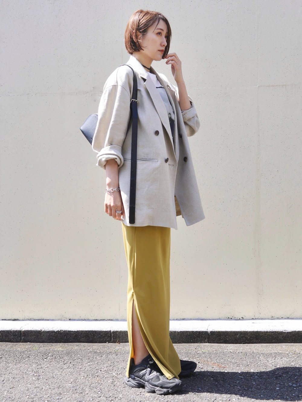 ホワイト系のTシャツ/カットソー、イエロー系のスカート、ブラック系のショルダーバッグを着用したレディースの春コーディネートの2枚目の写真