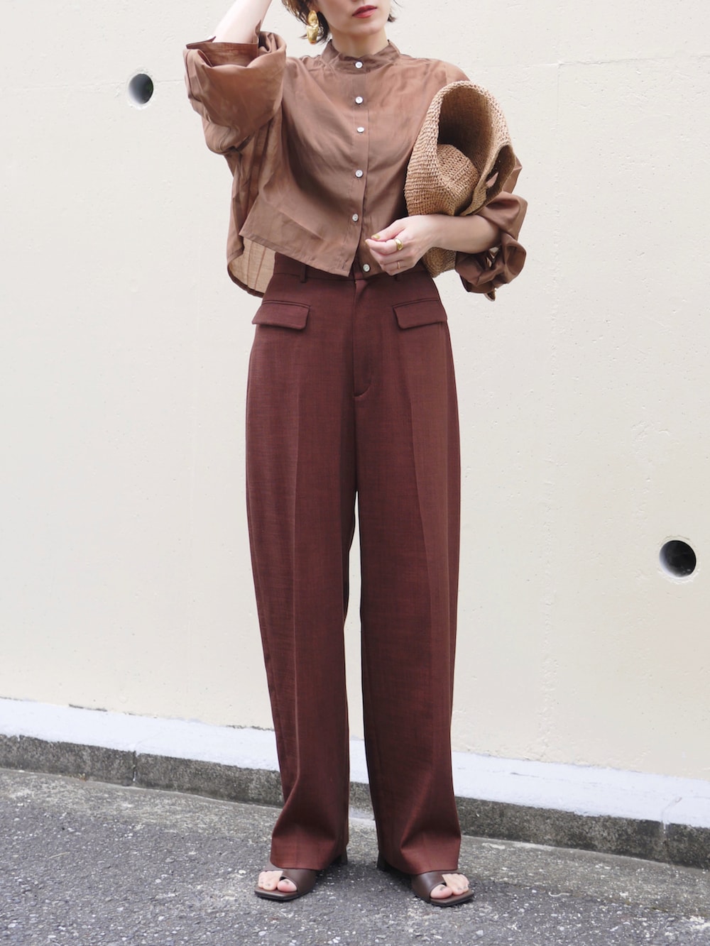 ブラウン系のシャツ/ブラウス、レッド系のスラックス、ブラウン系のかごバッグを着用したレディースの夏コーディネートの2枚目の写真