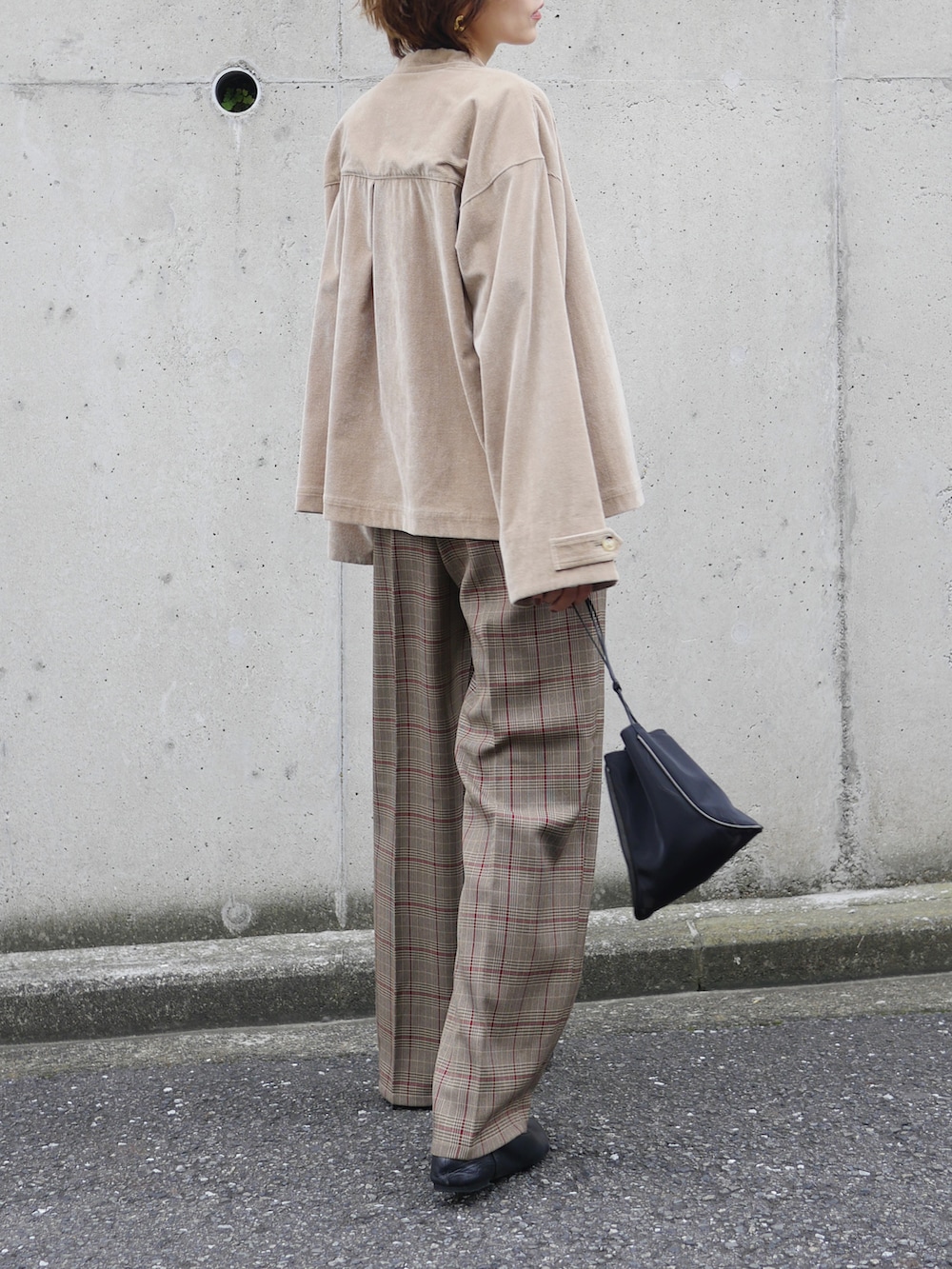 ブラウン系のブルゾン、ブラウン系のパンツ、ホワイト系のタンクトップを着用したレディースの秋コーディネートの3枚目の写真