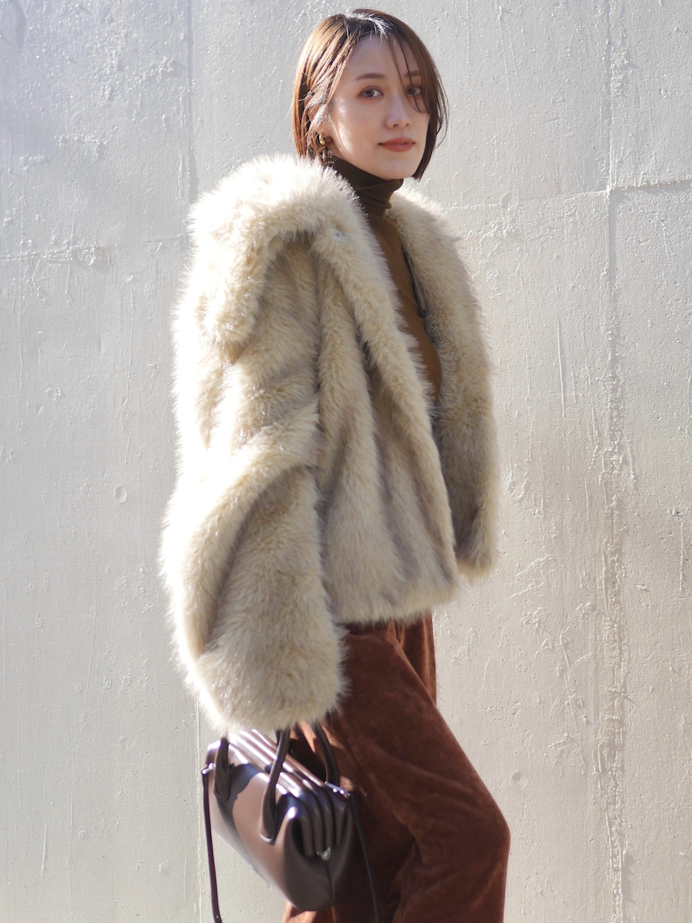 ホワイト系のその他アウター、ブラウン系のショルダーバッグ、ブラウン系のその他パンツを着用したレディースの冬コーディネートの3枚目の写真