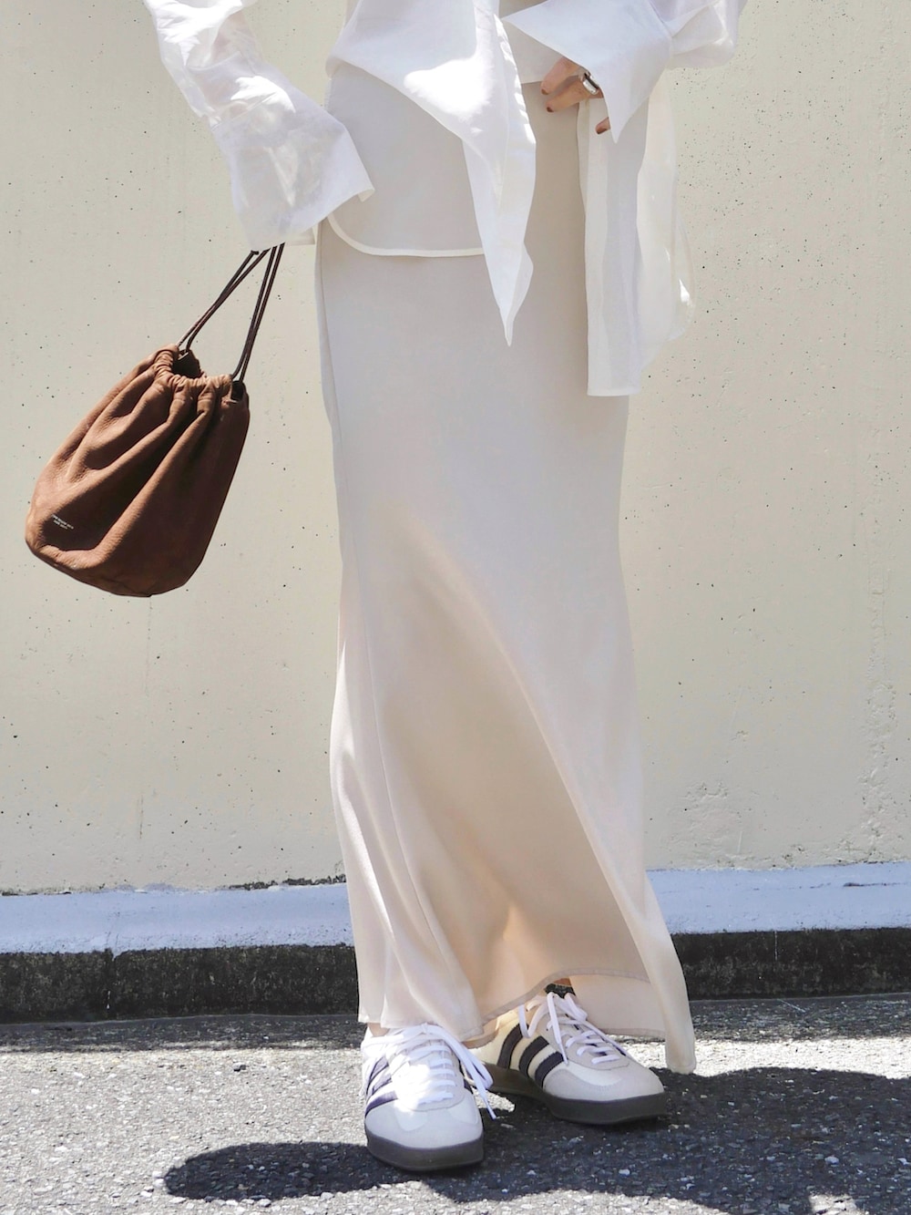 ホワイト系のシャツ/ブラウス、ホワイト系のスニーカー、ブラウン系のトートバッグを着用したレディースの春コーディネートの5枚目の写真