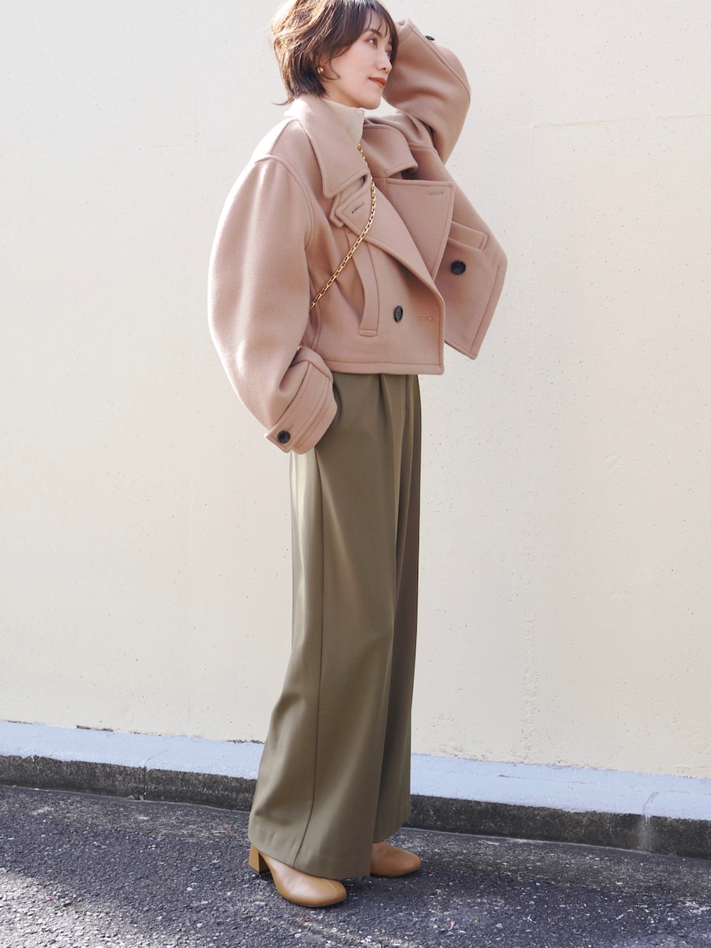 ベージュ系のピーコート、グリーン系のサロペット/オーバーオール、ベージュ系のシャツ/ブラウスを着用したレディースの秋コーディネートの4枚目の写真
