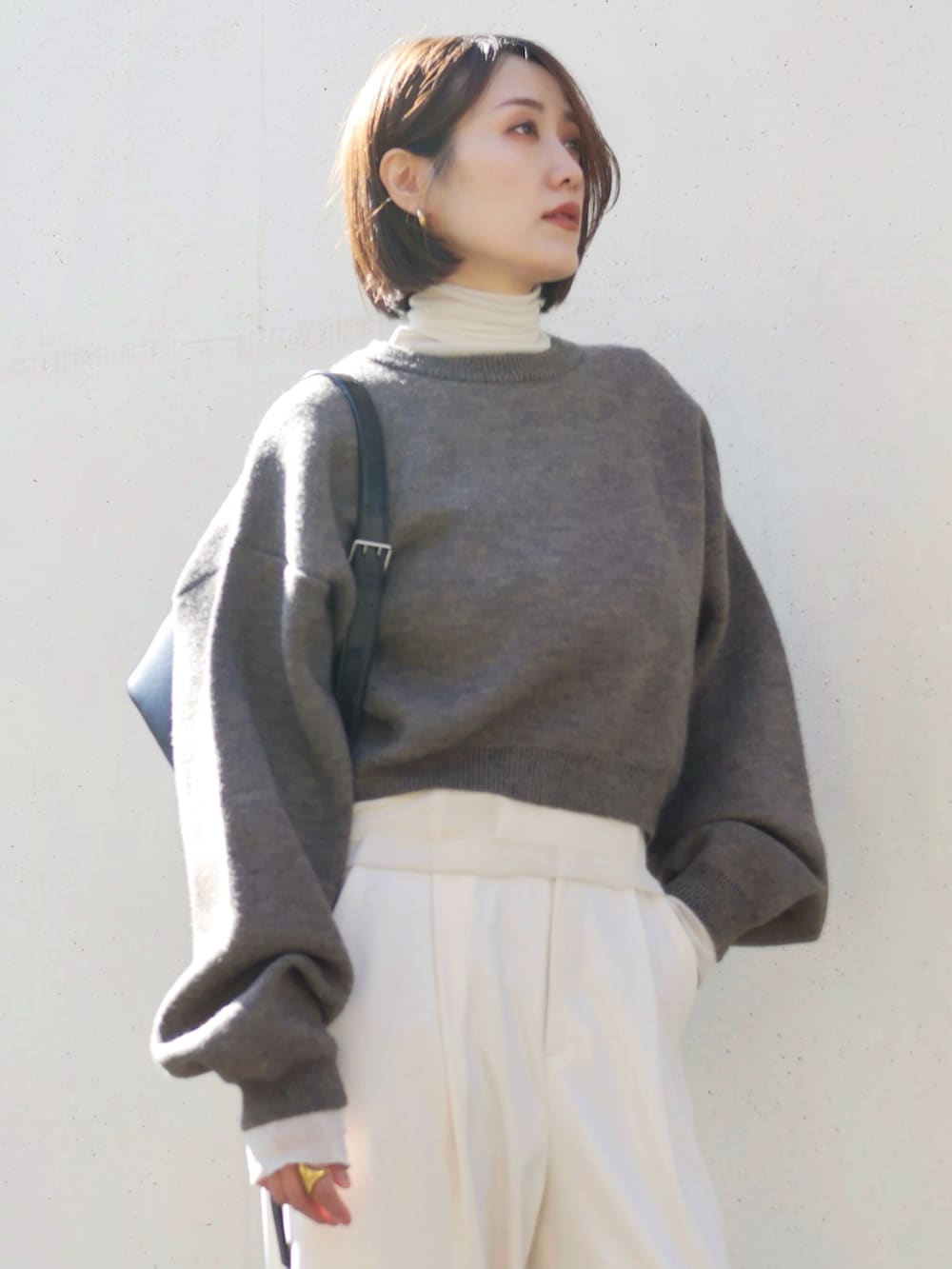 ブラウン系のニット/セーター、ブラック系のブーツ、ホワイト系のTシャツ/カットソーを着用したレディースの冬コーディネートの5枚目の写真