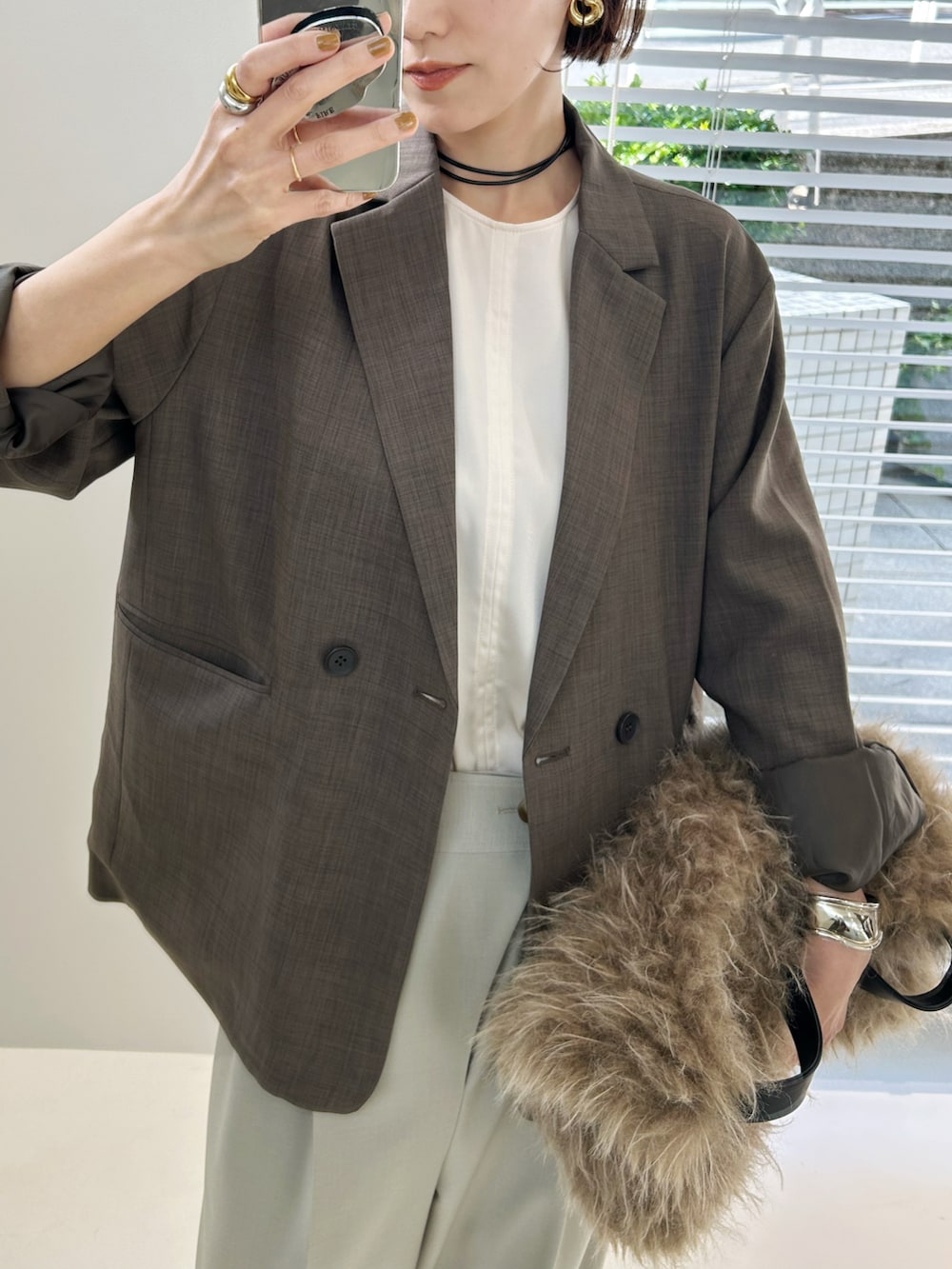 ベージュ系のテーラードジャケット、ベージュ系のショルダーバッグ、ベージュ系のスラックスを着用したレディースの秋コーディネートの3枚目の写真