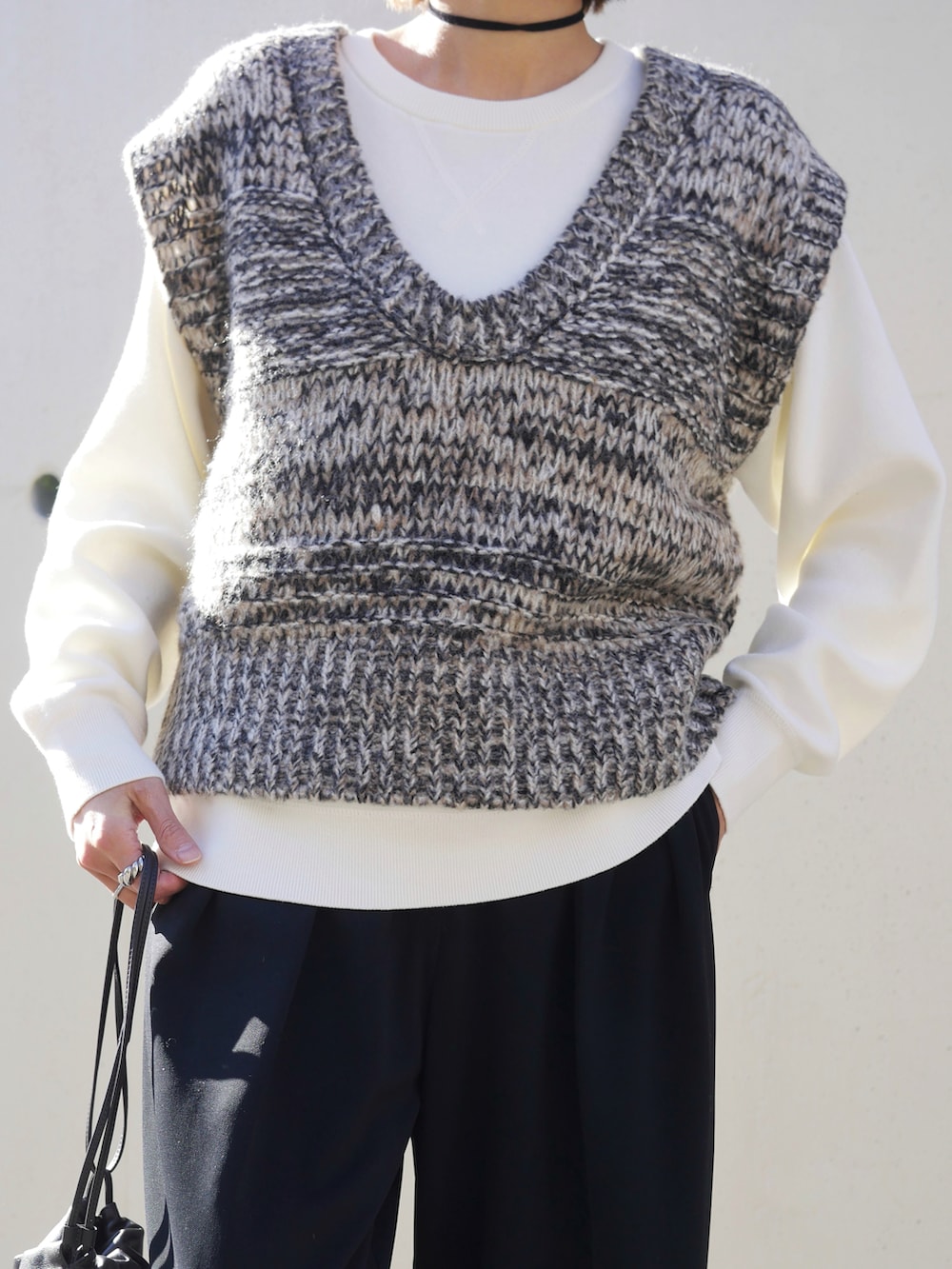 グレー系のベスト、ブラック系のブーツ、ブラック系のその他パンツを着用したレディースの冬コーディネートの3枚目の写真