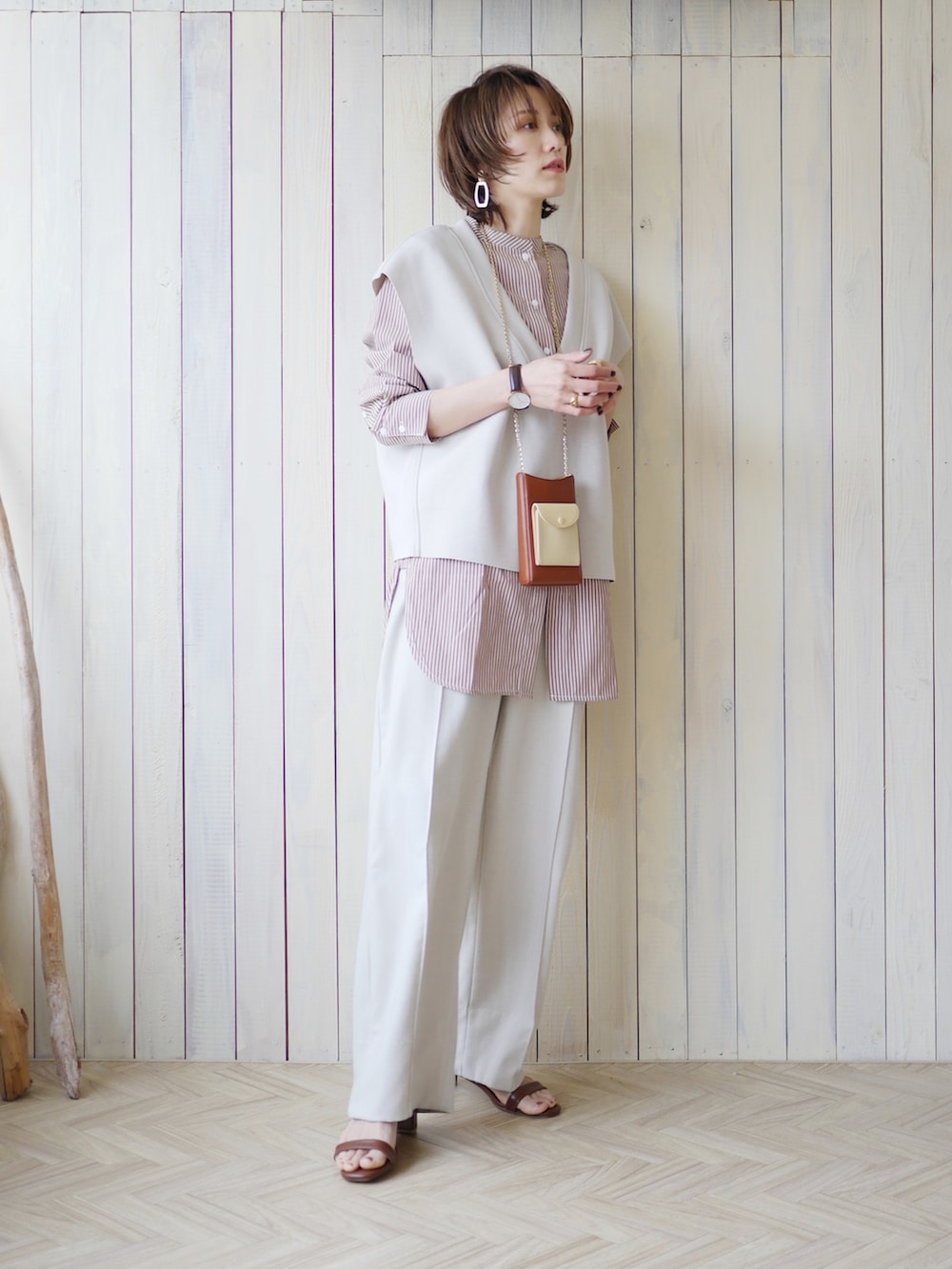 ブラウン系のシャツ/ブラウス、グレー系のベスト、ホワイト系のスラックスを着用したレディースの春コーディネートの3枚目の写真