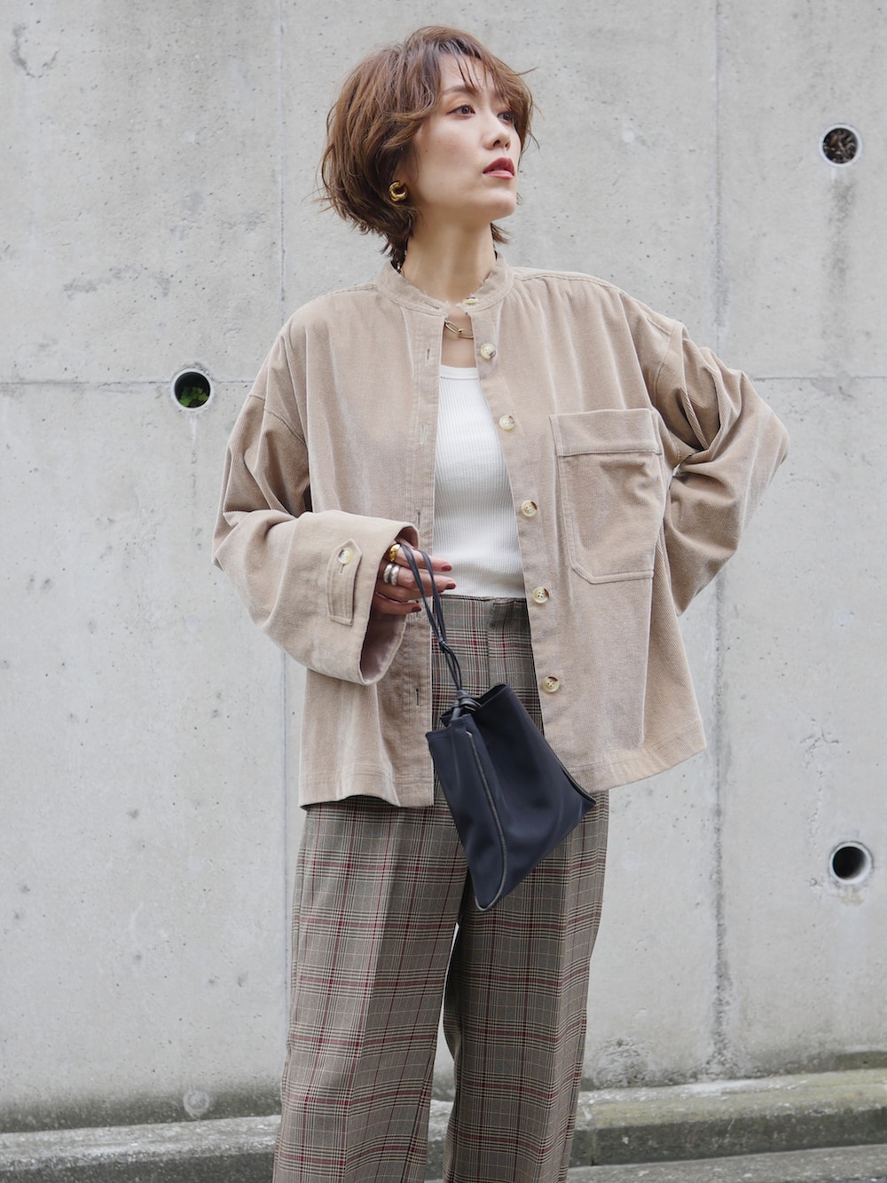 ブラウン系のブルゾン、ブラウン系のパンツ、ホワイト系のタンクトップを着用したレディースの秋コーディネートの5枚目の写真