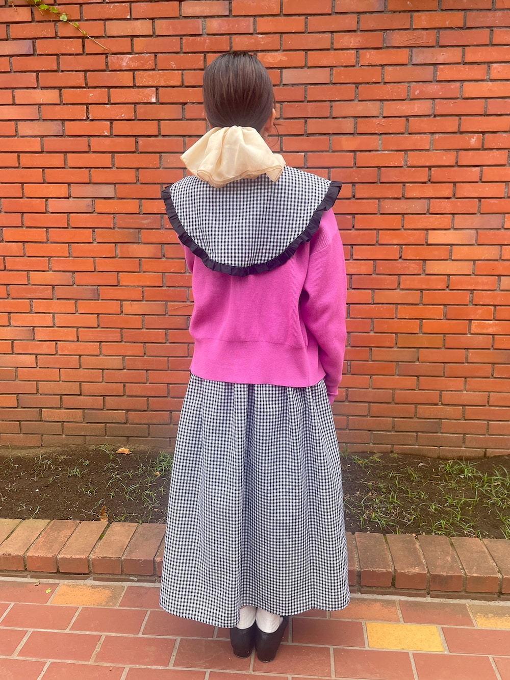 ブラック系のローファー、ピンク系のカーディガン/ボレロ、ブラック系のワンピースを着用したレディースの春コーディネートの3枚目の写真