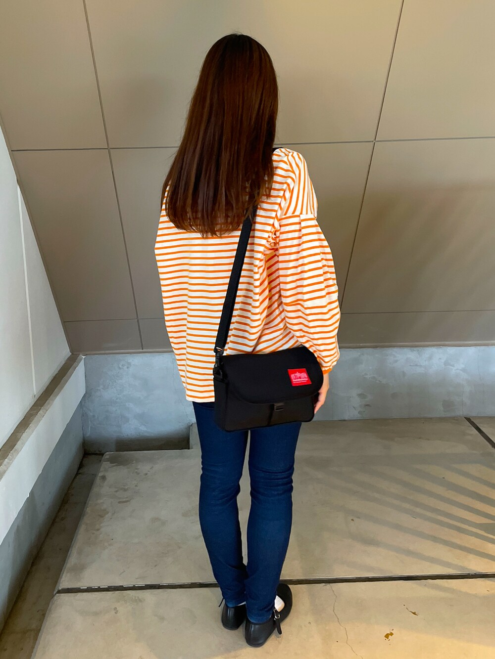 オレンジ系のTシャツ/カットソー、ブルー系のパンツ、ブラック系のバレエシューズを着用したレディースの春コーディネートの2枚目の写真