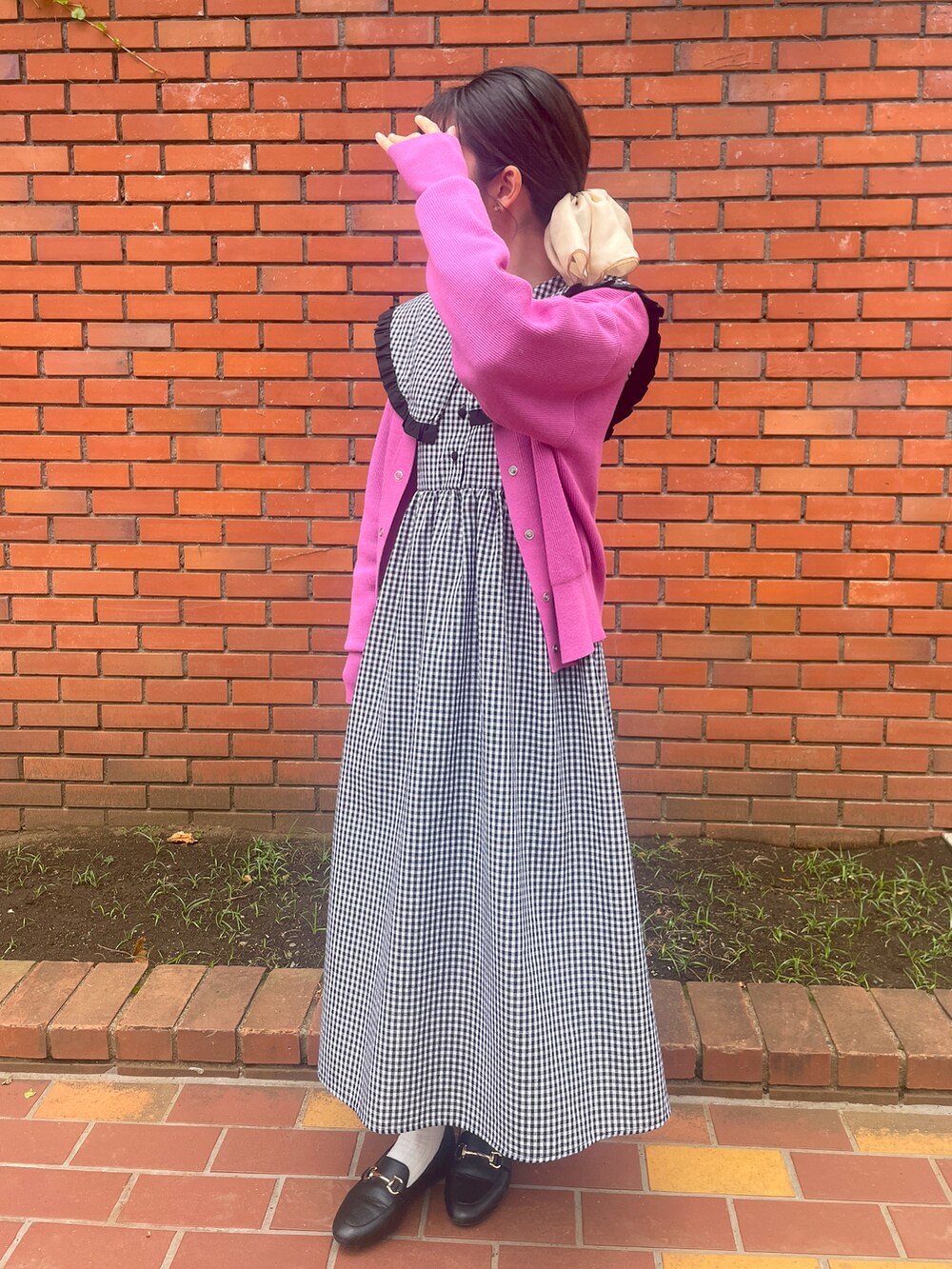 ブラック系のローファー、ピンク系のカーディガン/ボレロ、ブラック系のワンピースを着用したレディースの春コーディネートの2枚目の写真