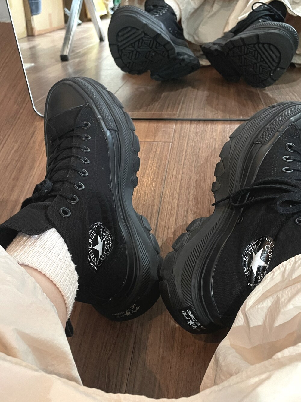 グリーン系のニット/セーター、ホワイト系のワンピース、ブラック系のスニーカーを着用したレディースの秋コーディネートの2枚目の写真