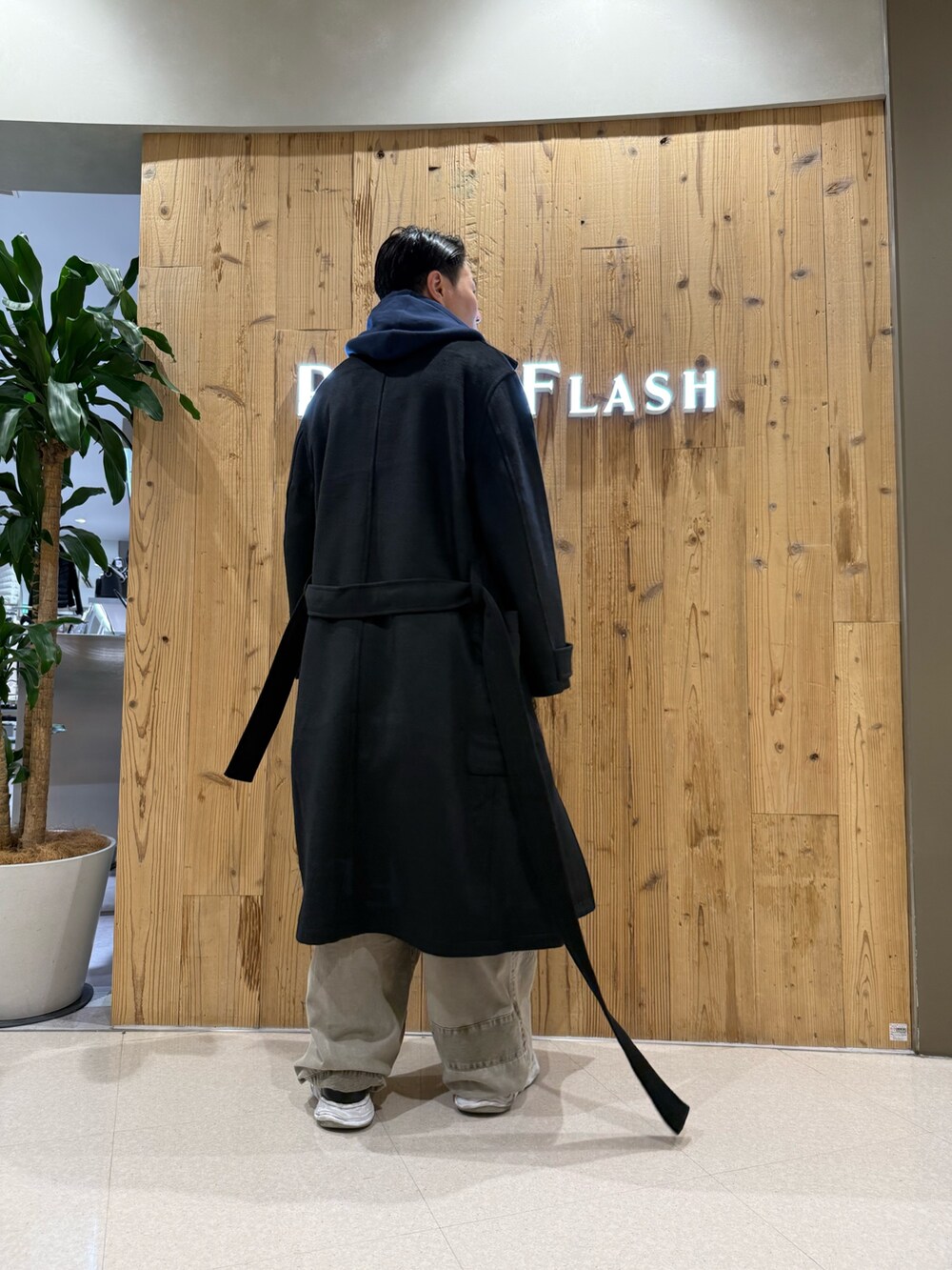 ブラック系のトレンチコートを着用したメンズの秋コーディネートの2枚目の写真