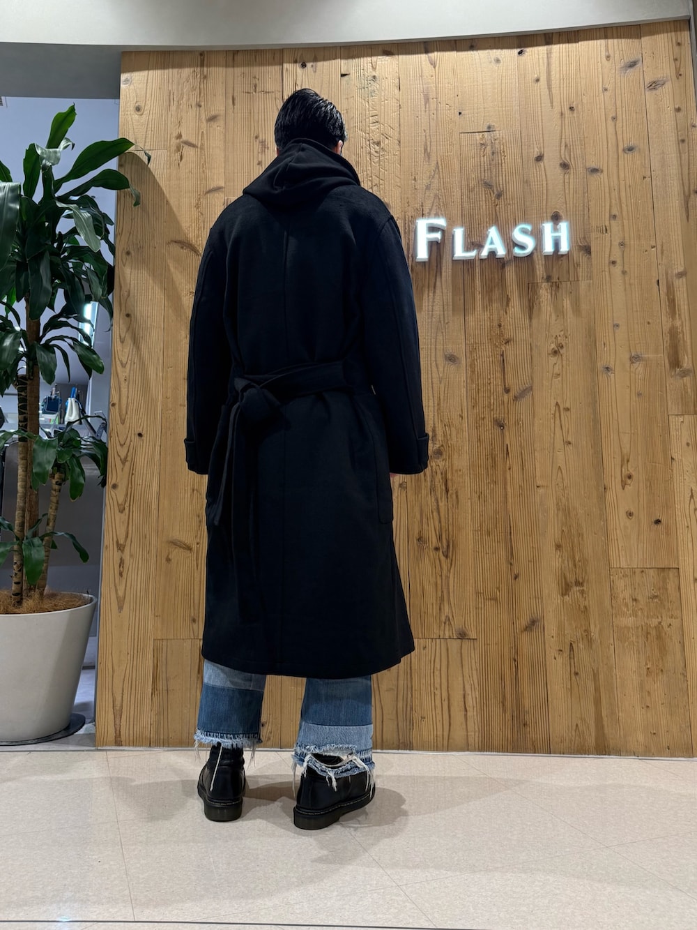 ブラック系のパーカー、ブラック系のトレンチコートを着用したメンズの冬コーディネートの2枚目の写真