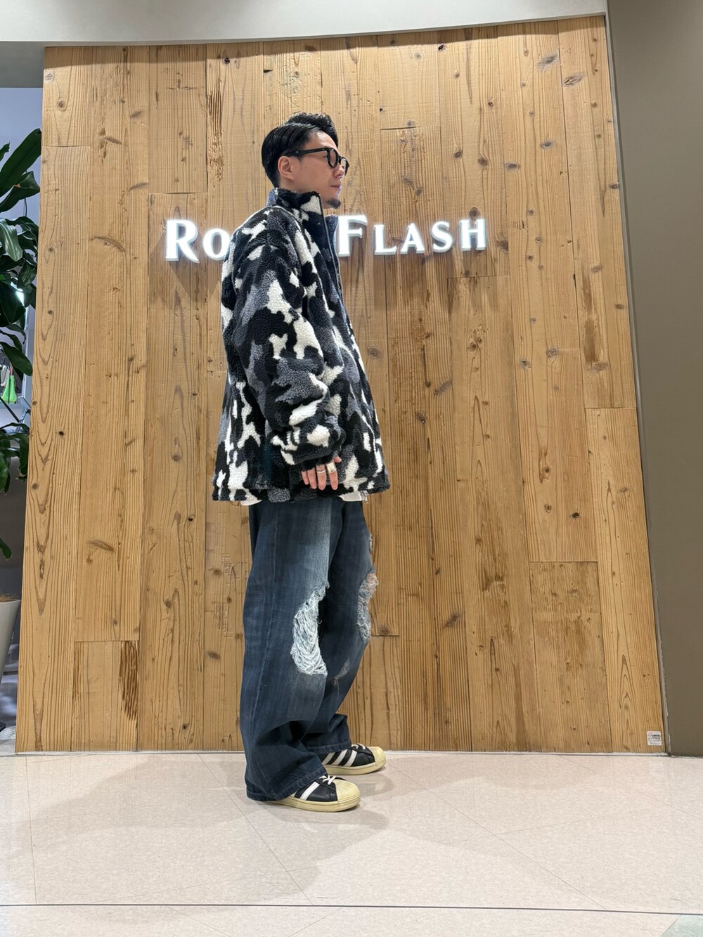ブラック系のブルゾン、ブルー系のデニムパンツを着用したメンズの冬コーディネートの4枚目の写真