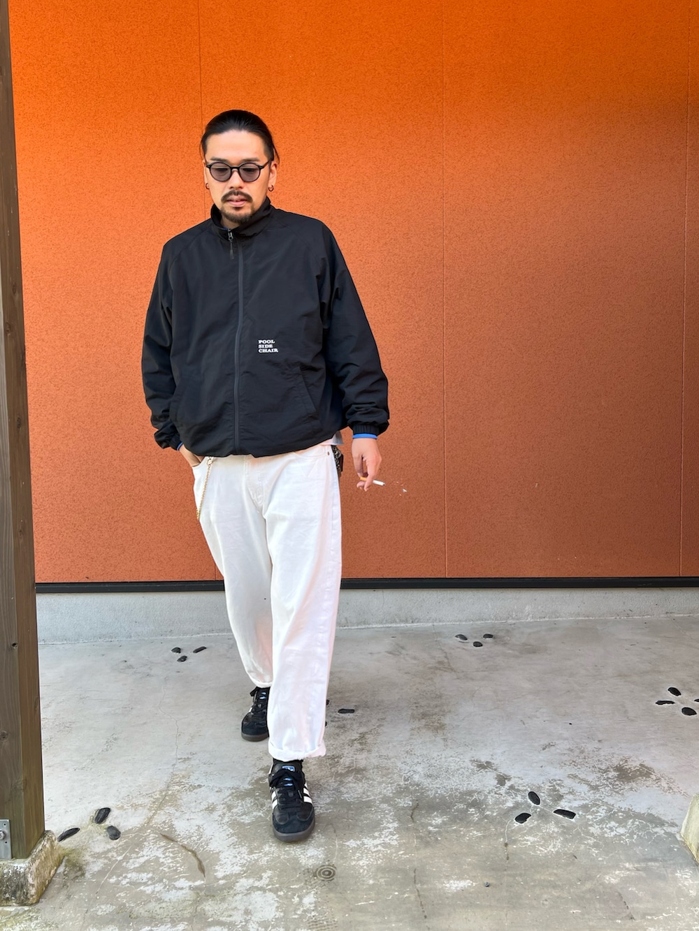 ブラック系のスニーカー、ホワイト系のデニムパンツ、ブラック系のナイロンジャケットを着用したメンズの冬コーディネートの3枚目の写真