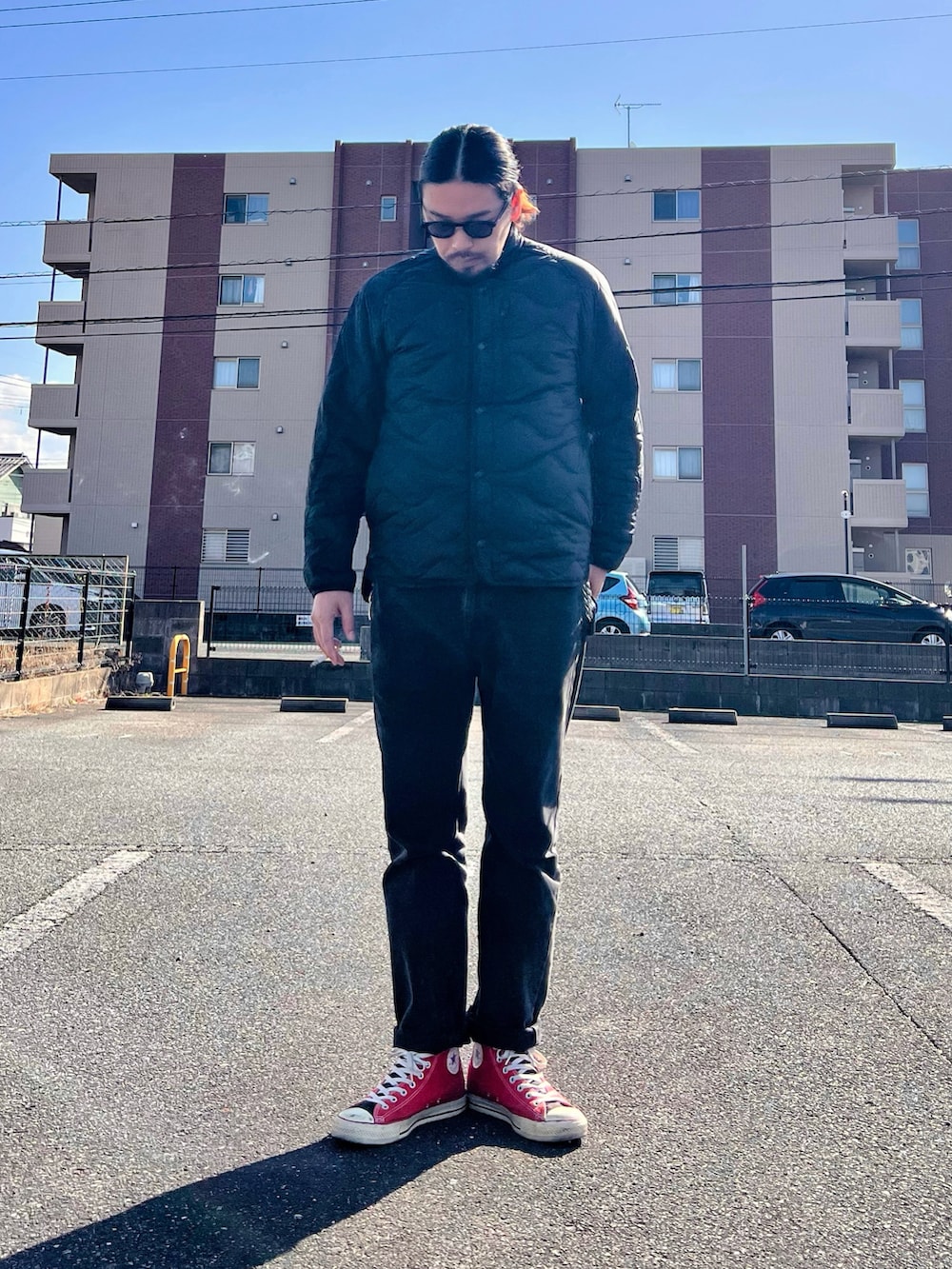 ブラック系のジャケット/アウター、ブラック系のデニムパンツ、レッド系のスニーカーを着用したメンズの冬コーディネートの2枚目の写真