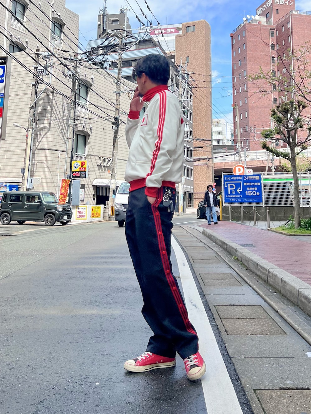 レッド系のスニーカー、ホワイト系のジャージ、ブラック系のパンツを着用したメンズの春コーディネートの2枚目の写真