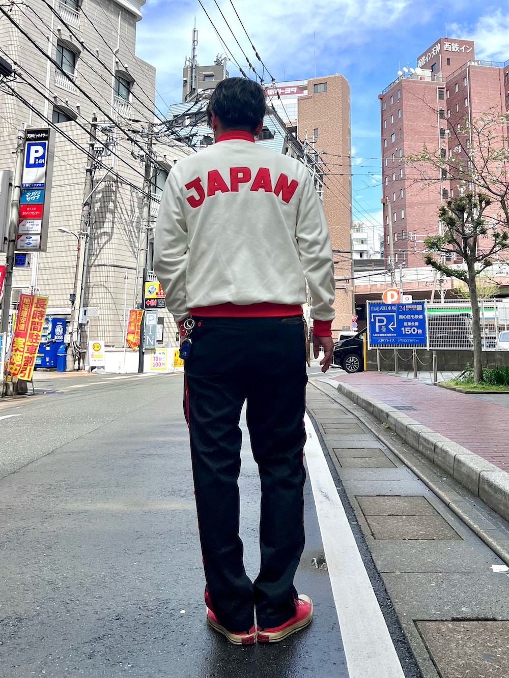 レッド系のスニーカー、ホワイト系のジャージ、ブラック系のパンツを着用したメンズの春コーディネートの3枚目の写真