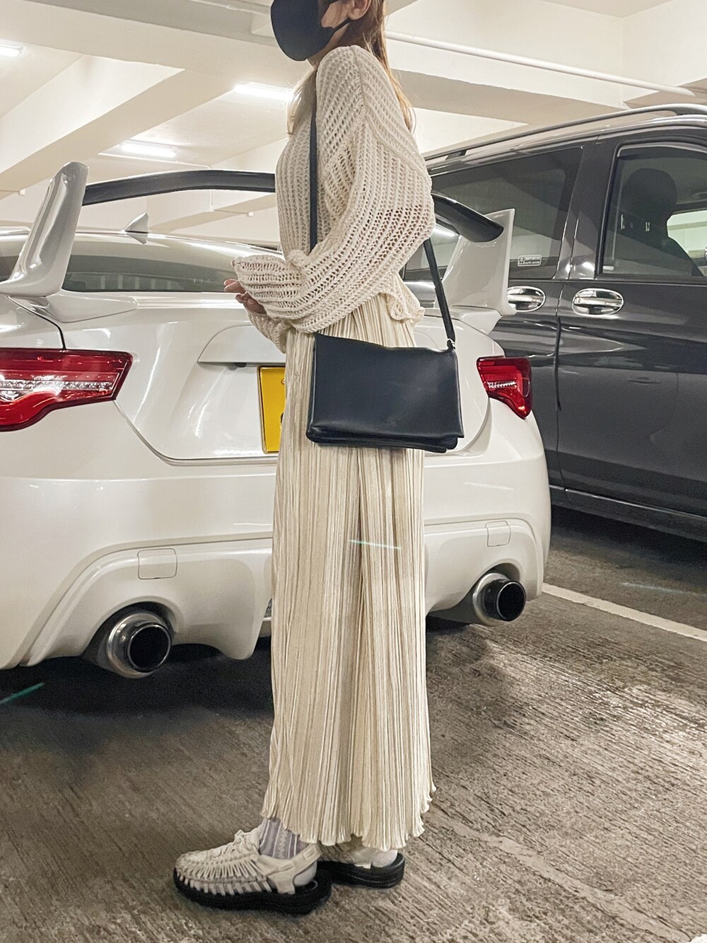 ホワイト系のサンダル、ホワイト系のスカート、ベージュ系のニット/セーターを着用したレディースの冬コーディネートの3枚目の写真