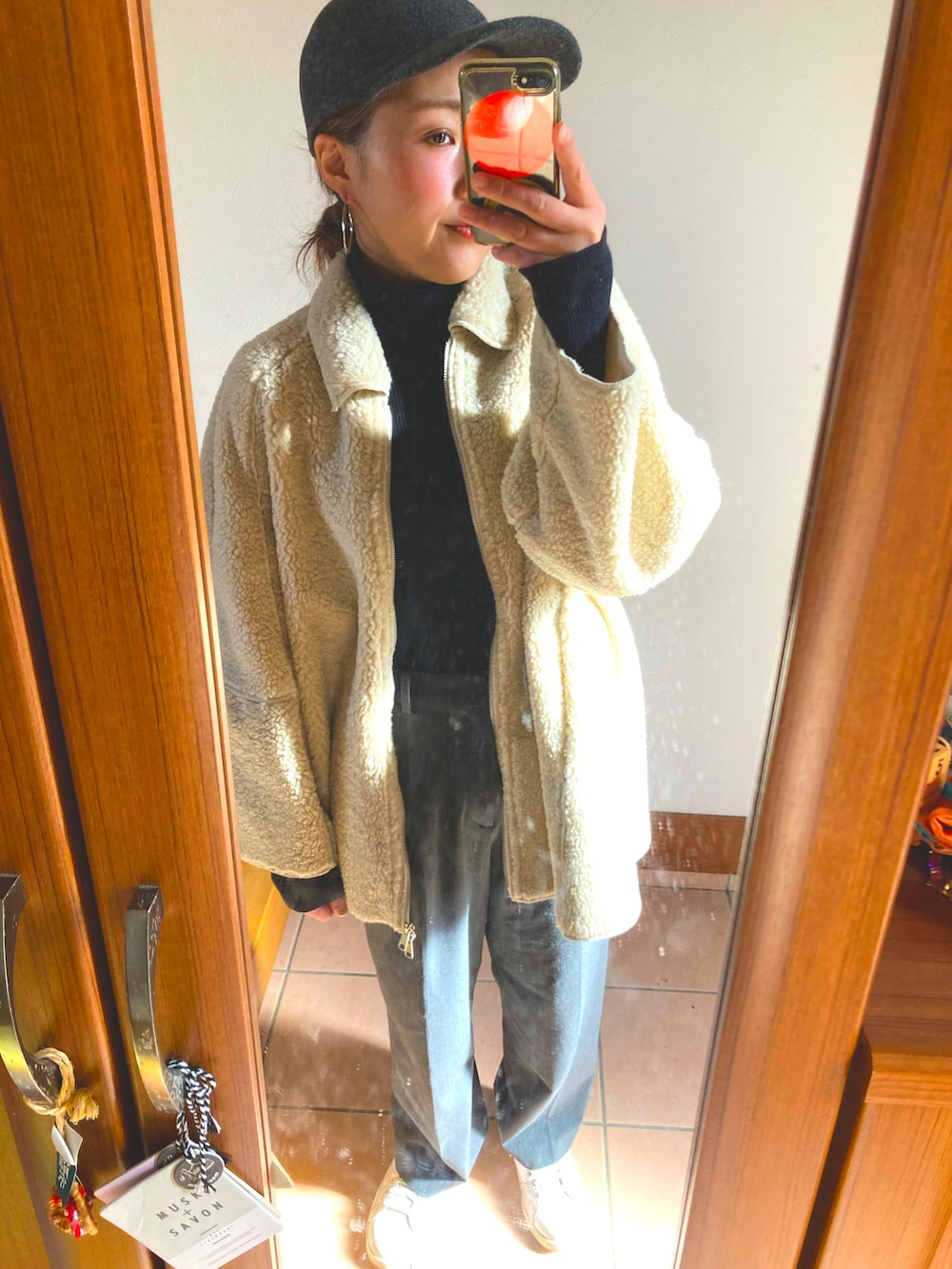 ブラック系のニット/セーター、ホワイト系のその他アウター、グレー系のスラックスを着用したレディースの冬コーディネートの3枚目の写真