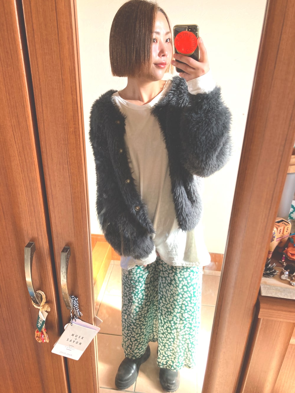 グリーン系のスカート、ホワイト系のTシャツ/カットソー、グレー系のカーディガン/ボレロを着用したレディースの冬コーディネートの4枚目の写真