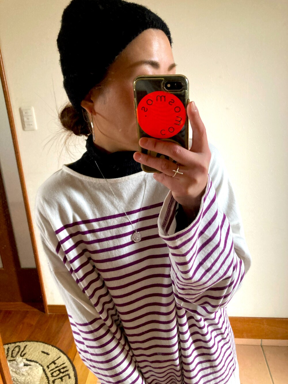 パープル系のTシャツ/カットソー、ブラック系のスカート、ブラック系のブーツを着用したレディースの冬コーディネートの3枚目の写真