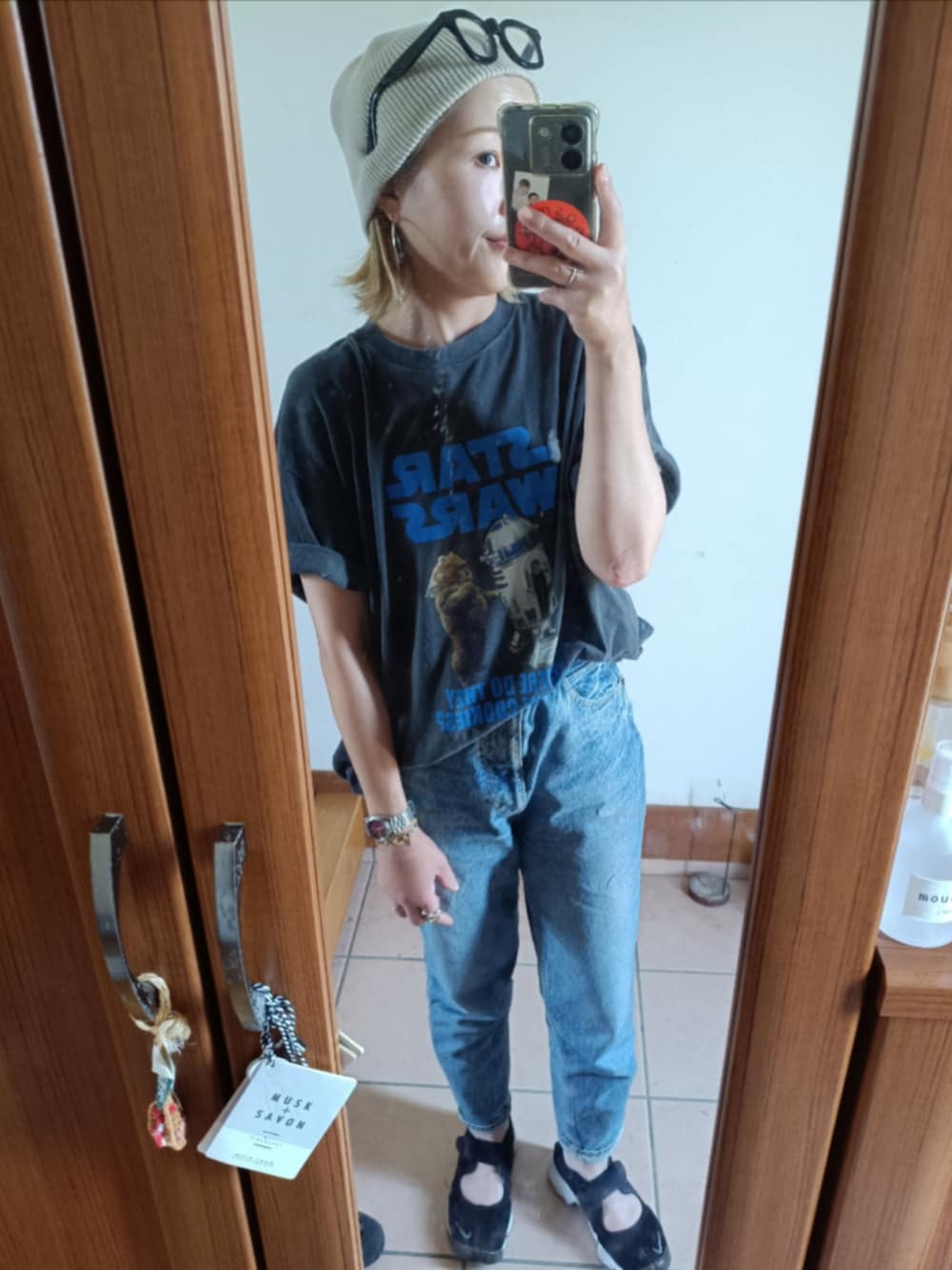 グレー系のTシャツ/カットソー、ブルー系のデニムパンツ、ブラック系のスニーカーを着用したレディースの夏コーディネートの2枚目の写真