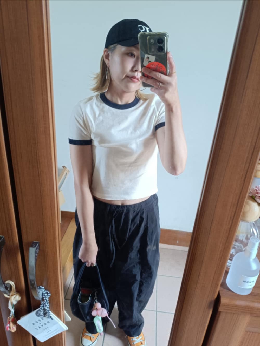 ホワイト系のTシャツ/カットソー、ブラック系のその他パンツ、ブラック系のキャップを着用したレディースの夏コーディネートの2枚目の写真