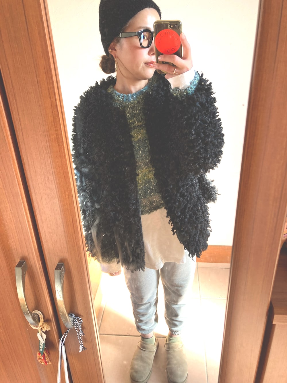 グリーン系のニット/セーター、ホワイト系のTシャツ/カットソー、グレー系のスウェットパンツを着用したレディースの冬コーディネートの3枚目の写真