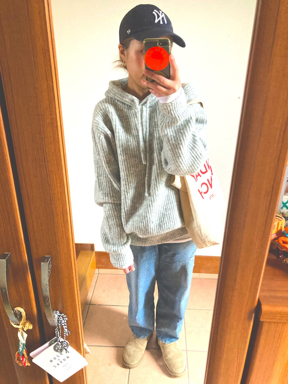 グレー系のニット/セーター、ブルー系のデニムパンツ、ベージュ系のブーツを着用したレディースの冬コーディネートの3枚目の写真