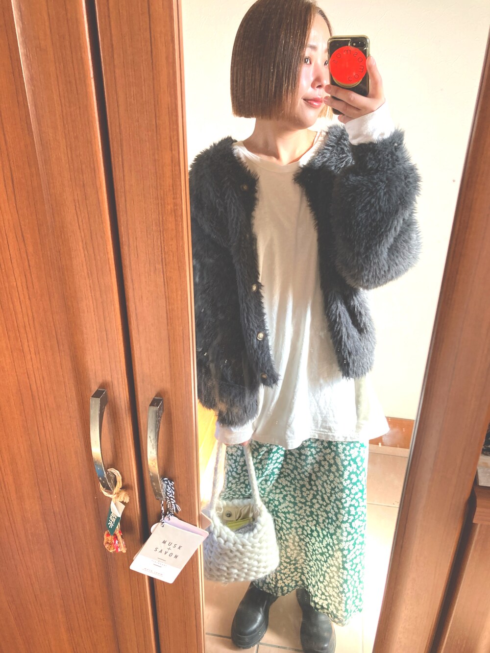グリーン系のスカート、ホワイト系のTシャツ/カットソー、グレー系のカーディガン/ボレロを着用したレディースの冬コーディネートの3枚目の写真