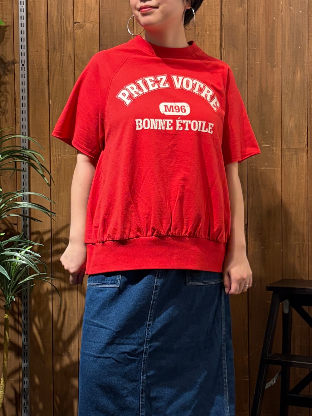 レッド系のTシャツ/カットソー、ブルー系のスカート、ブラック系のトートバッグを着用したレディースの夏コーディネートの4枚目の写真
