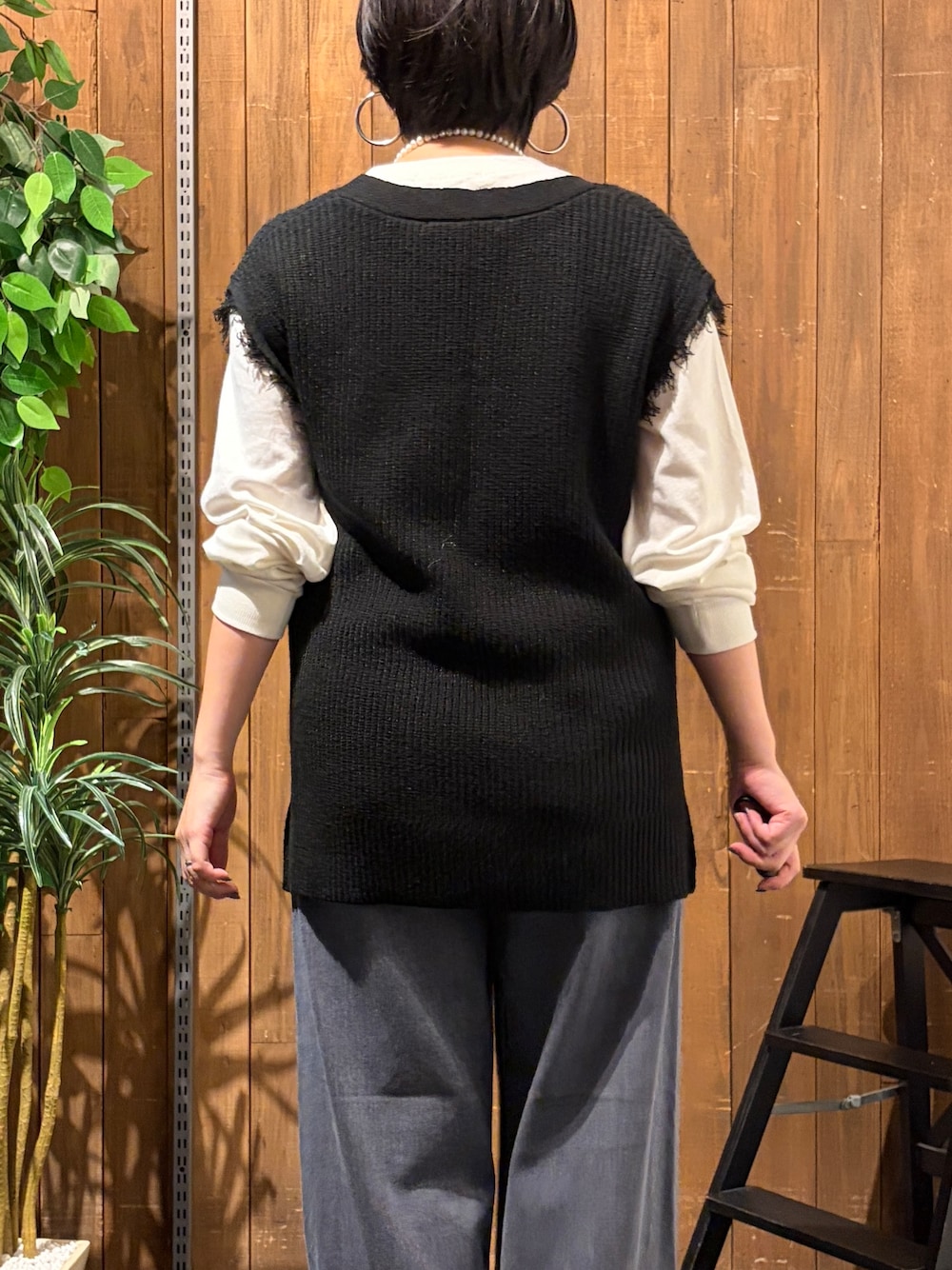 ブラック系のデニムパンツ、ホワイト系のTシャツ/カットソー、ブラック系のベストを着用したレディースの秋コーディネートの7枚目の写真