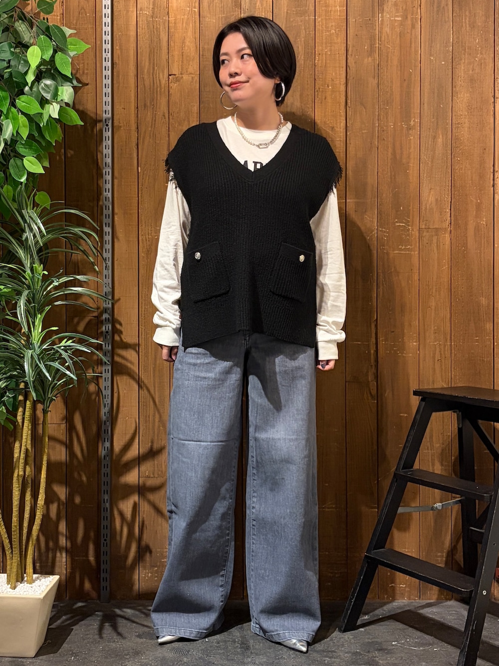 ブラック系のデニムパンツ、ホワイト系のTシャツ/カットソー、ブラック系のベストを着用したレディースの秋コーディネートの8枚目の写真