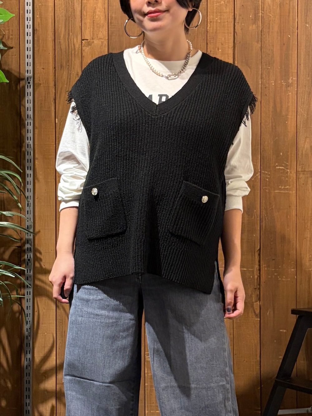 ブラック系のデニムパンツ、ホワイト系のTシャツ/カットソー、ブラック系のベストを着用したレディースの秋コーディネートの5枚目の写真