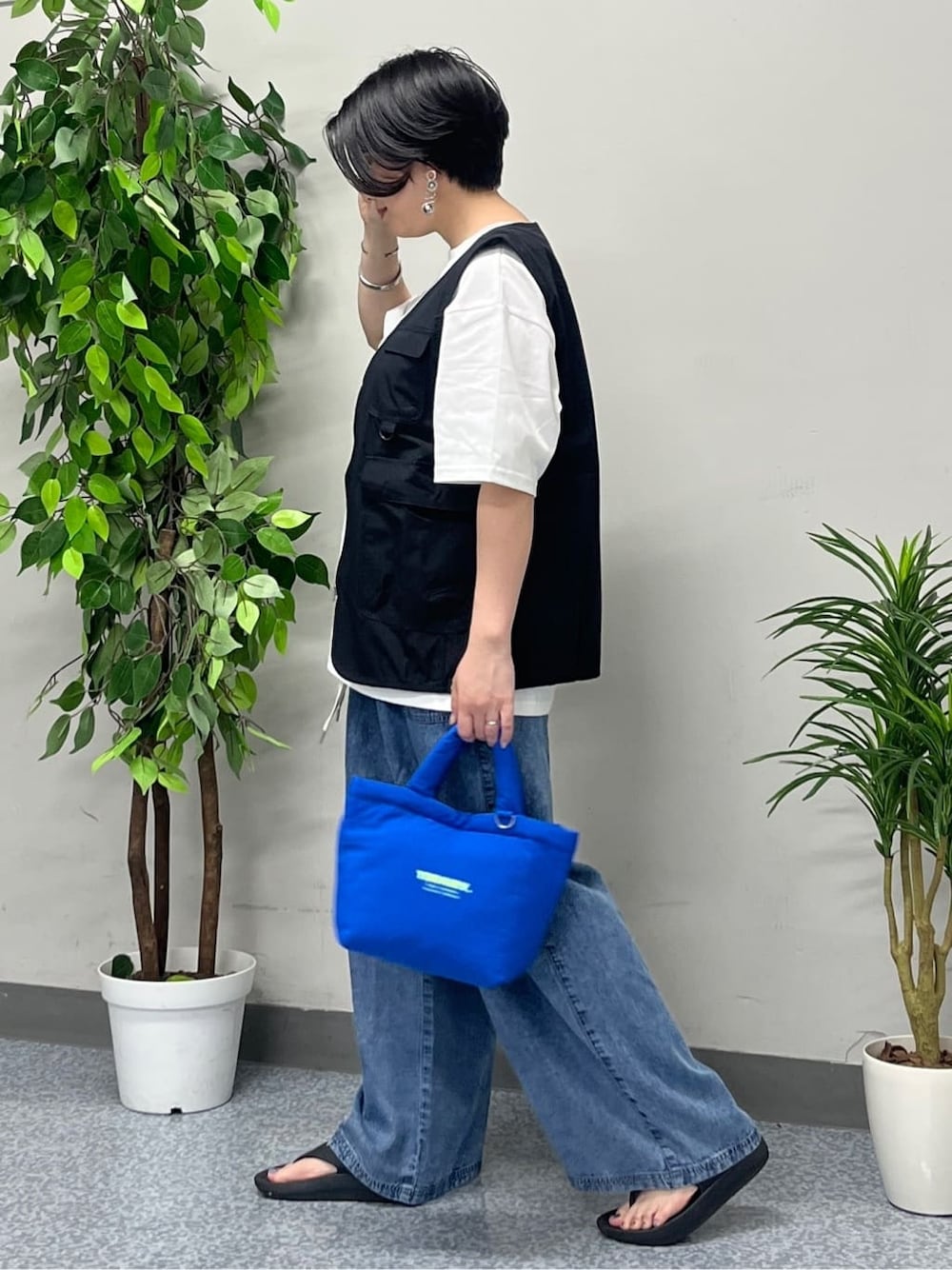 ホワイト系のTシャツ/カットソー、ブラック系のシャツ/ブラウス、ブルー系のデニムパンツを着用したレディースの春コーディネートの3枚目の写真